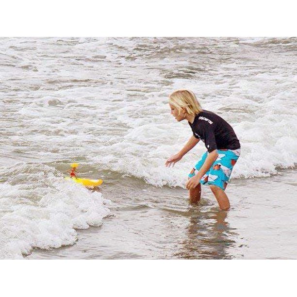 enfant jouant dans les vagues au surfer dudes